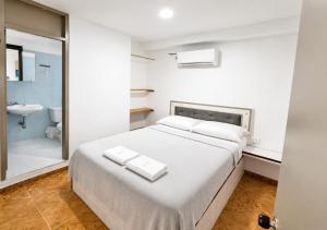a bedroom with a bed and a bathroom with a sink at Ocean Blue Centro Histórico Hotel in Santa Marta