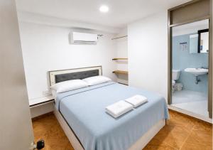 a bedroom with a bed and a bathroom with a sink at Ocean Blue Centro Histórico Hotel in Santa Marta