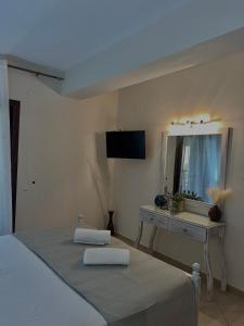 a bedroom with a bed and a vanity with a mirror at Sea and Stone Apartment in Afitos