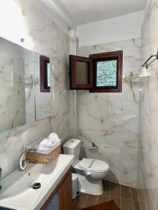 a bathroom with a toilet and a sink at Sea and Stone Apartment in Afitos