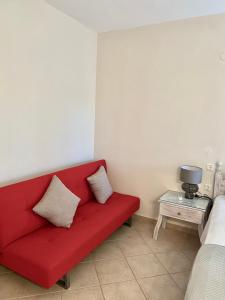 a red couch in a room with a bed at Sea and Stone Apartment in Afitos