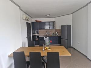 eine Küche und ein Esszimmer mit einem Holztisch und Stühlen in der Unterkunft Dan-Mari in Baltschik