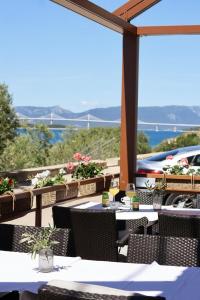 a restaurant with tables and chairs and a view of the water at Villa Ancora in Neum