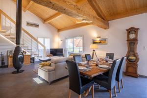 a dining room with a table and a clock at Maison Chalet in Le Nayrac