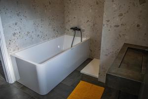 a white bath tub in a bathroom with a yellow rug at Villa Angela in Orebić +107 photos