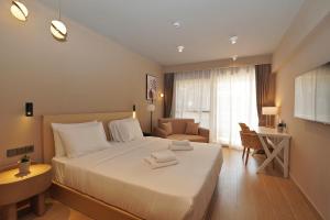 a bedroom with a bed and a chair and a couch at Ionian Crown Suites in Barbati in Barbati