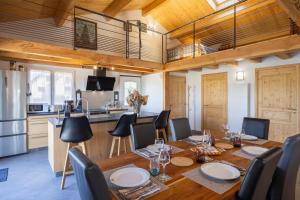 a dining room with a table and chairs and a kitchen at Maison Chalet in Le Nayrac