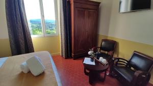 a hotel room with a bed and a table and chairs at Les Terrasses d'Antonin in Grambois
