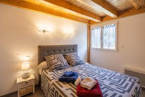 a bedroom with a bed and a window at Maison Chalet in Le Nayrac