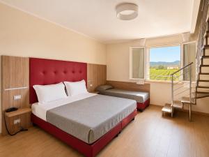 a bedroom with a red bed and a stair case at Hotel Residence Vallecorsa in Vada