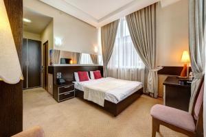 a hotel room with a bed and a chair at Terra Nova Spa Hotel in Hatne