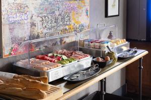 a buffet with hot dogs and bread on a table at Hôtel Fabric in Paris