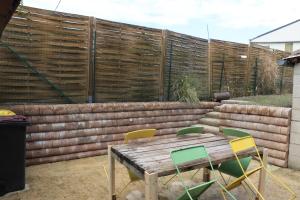 a wooden table and chairs in front of a fence at M28 - Maison de campagne avec climatisation in Barby