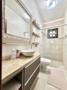 a bathroom with a sink and a toilet at Quarto 2P Joinville Costa e Silva perto Centro in Joinville +18 photos