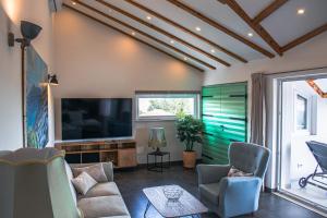 a living room with a flat screen tv and chairs at Villa Angela in Orebić