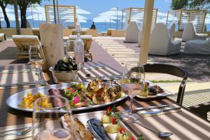 a table with a plate of food and wine glasses at Ionian Crown Suites in Barbati in Barbati