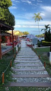 a pathway leading to a beach with tables and chairs at Villas do Pratagy Bambu 2 in Maceió +13 photos