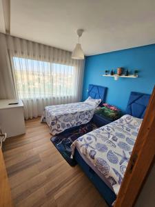 zwei Betten in einem Zimmer mit blauen Wänden in der Unterkunft Bleu Beach uniquement pour famille in Sidi Rahal + 39 Fotos