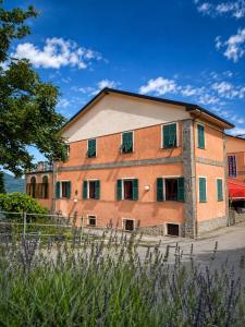 a large brick building with green shuttered windows at Albergo La Veranda in Tavarone