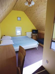 a bedroom with a bed and a tv in a room at Dom Pod Gruszką in Pobierowo
