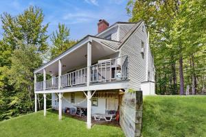 a house with a wrap around porch and a balcony at GOPI Notch in Franconia