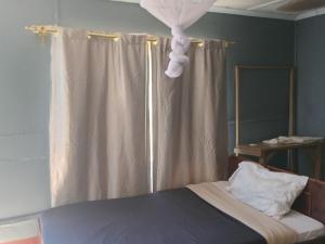 a bedroom with a bed with a shower curtain at Turacova Safaris & Accommodation in Mara Simba
