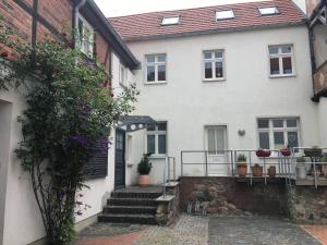 a white house with a staircase leading to the front door at Familienhaus Stadtmitte in Neustrelitz