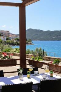 a table with wine glasses and a view of the water at Villa Ancora in Neum