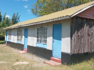 an old building with blue and white doors at Turacova Safaris & Accommodation in Mara Simba