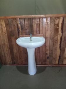 a white sink in front of a wooden wall at Turacova Safaris & Accommodation in Mara Simba