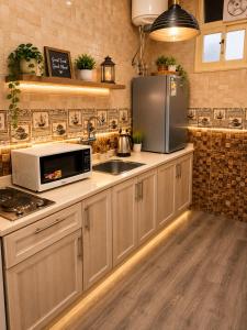 a kitchen with a sink and a refrigerator at ليالي أكنان للشقق المخدومة فرع2 in Abha
