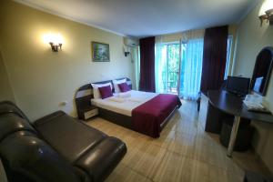 a hotel room with a bed and a couch at Hotel Diandra in Eforie Nord