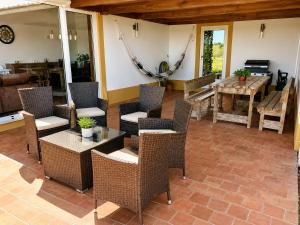 a patio with wicker chairs and a table at Pouso Du'Vagar in Cuba