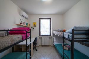 a dorm room with two bunk beds and a window at Interno 8 - Franciacorta x 7 in Passirano