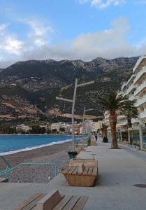 a bench on a beach next to a building at MC4 Residences in Loutraki