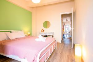 a bedroom with a bed and a green wall at MC4 Residences in Loutraki