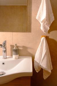a bathroom with a white towel hanging on a sink at MC4 Residences in Loutraki +3 photos
