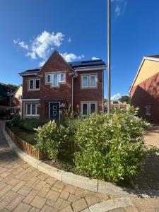 a red brick house with bushes in front of it at The Trinity - Double Room Suite 1 with Study and En-suite in High Wycombe