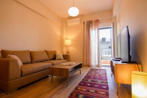 a living room with a couch and a tv at MC4 Residences in Loutraki