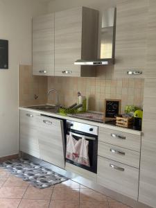a kitchen with a sink and a stove with towels at NORA House in Savona