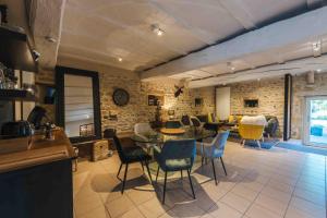 a kitchen and living room with a table and chairs at Les Tilleuls de Marie in Saint-Edmond