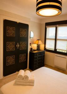 a bedroom with two towels on a bed and a window at La Tuiliere in Oraison