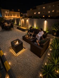 a group of people sitting on a patio at night at ليالي أكنان للشقق المخدومة فرع2 in Abha