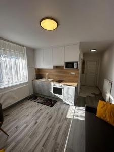 a kitchen with white cabinets and a wooden floor at Privet Apartman in Balatonfüred +12 photos