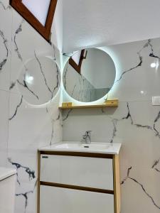 a bathroom with a sink and a mirror at Magnus Appartments in Dukat +48 photos