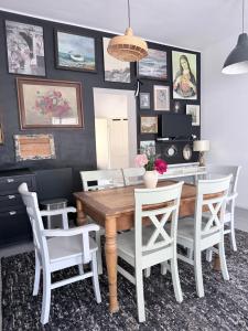a dining room with a wooden table and white chairs at Sowa Loft in Zagórze Śląskie +9 photos