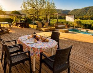 a table and chairs on a deck next to a pool at La Tuiliere in Oraison +11 photos
