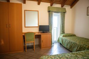 a room with a desk with a computer and a bed at Albergo La Veranda in Tavarone