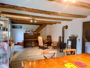 a living room with a wooden table and a piano at Maison mitoyenne avec terrasse in Asuel