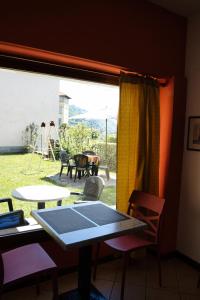 ein Tisch und Stühle in einem Zimmer mit Fenster in der Unterkunft L'Oasi Intelvese in Pellio Superiore